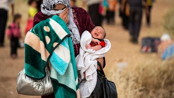 Flucht vor den Bomben. Eine Mutter mit ihrem vier Wochen alten Sohn überquert die syrische Grenze. Foto: Photo Unit/S. Rich, CC BY-NC 2.0.