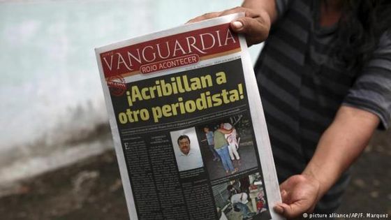 Ein Nachbar mit einer lokalen Zeitung, die über den Mord berichtet. Foto: picture alliance/AP/F. Marquez 