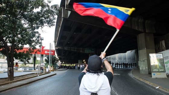 Ein Student weht während eines Protestes die Landesflagge den Sicherheitskräften entgegen. Foto: Marquinam. CC BY-NC-ND 2.0