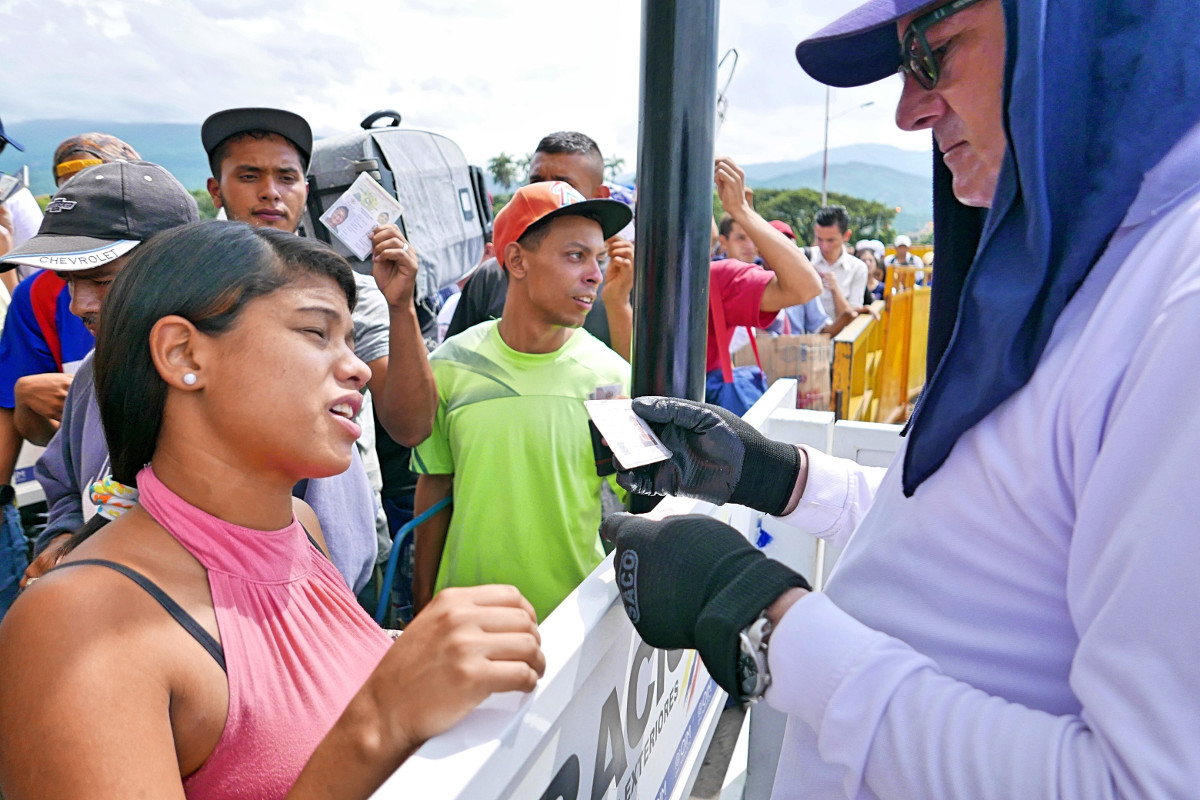 Ein kolumbianischer Migrationsbeamter kontrolliert die Einreisekarten und Ausweise auf der Grenzbrücke zwischen Venezuela und Kolumbien. Foto (2019): Adveniat/Philipp Lichterbeck